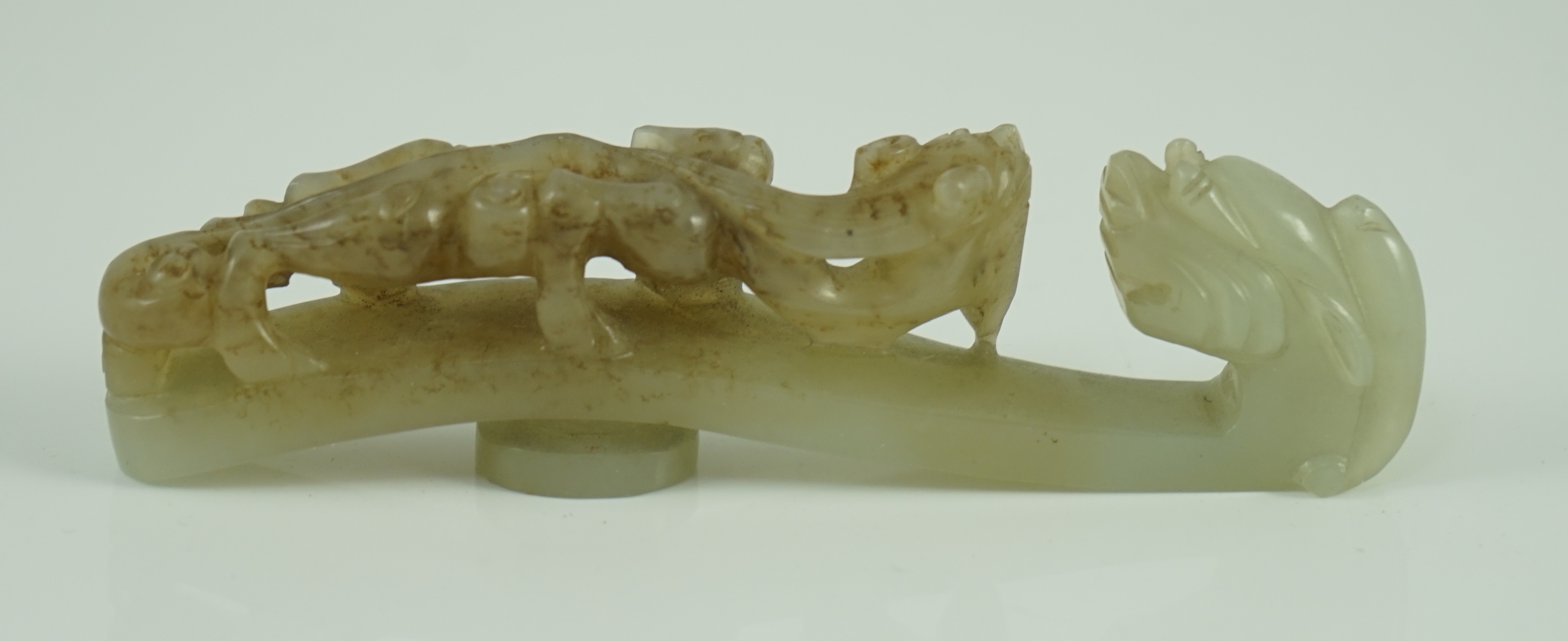 A Chinese pale celadon and brown jade ‘dragon’ belt hook, 18th/19th century 10.7 cm long